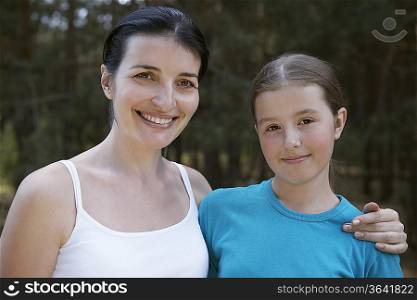 Portrait of mother embracing her daughter, outdoors