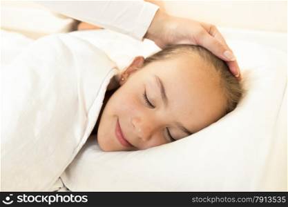 Portrait of mother hand caressing sleeping daughter on hand