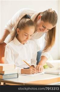 Portrait of mother helping daughter with preparing to exam