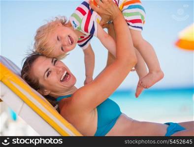 Portrait of mother playing with baby on beach