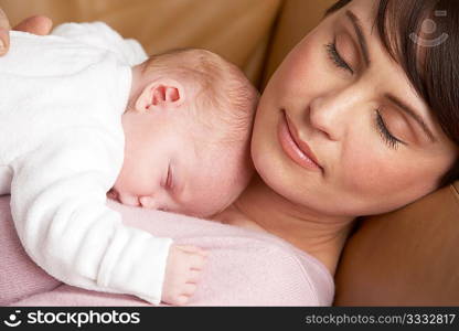 Portrait Of Mother Resting With Newborn Baby At Home