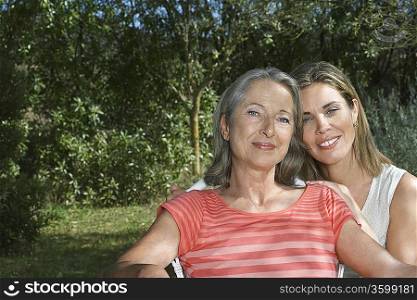 Portrait of mother with adult daughter in garden