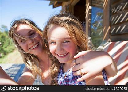 Portrait of mother with arm around daughter
