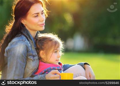 Portrait of mother with daughter relaxing outdoors, spending time together in warm sunny autumn day, loving happy family