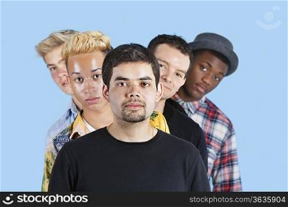 Portrait of multi-ethnic friends standing in line over blue background