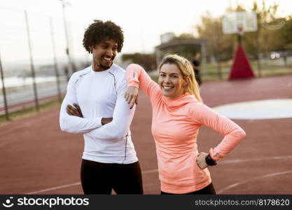 Portrait of multiracial couple of young runners resting after training