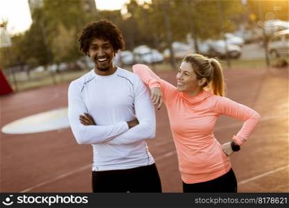 Portrait of multiracial couple of young runners resting after training