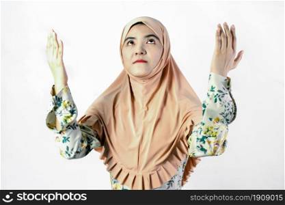 Portrait of Muslim woman wearing headscarf and praying for hope on white background
