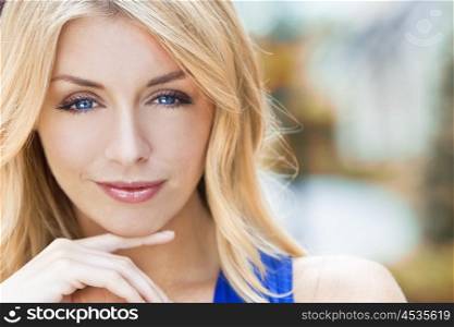 Portrait of naturally beautiful woman in her twenties with blond hair and blue eyes, shot outside in natural sunlight