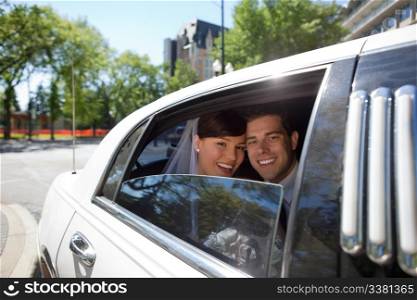 Portrait of newlywed couple in limousine