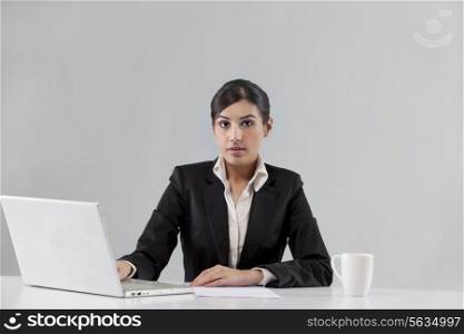 Portrait of news anchor with laptop and coffee against colored background