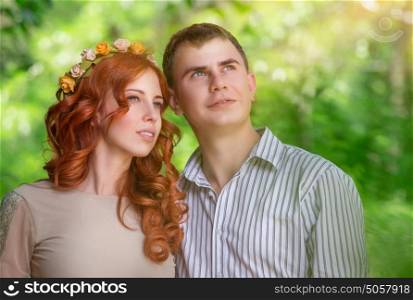Portrait of nice dreamy couple spending time together in fresh green spring park, with interest looking up in the sky, love and romantic relationship concept
