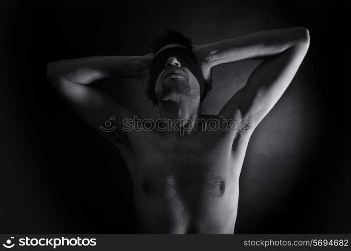 Portrait of nude young men blindfolded on a black background