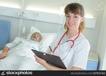 portrait of nurse holding file in hospital room