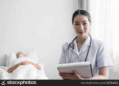 portrait of nurse smiling and senior man on bed at nursing home as background