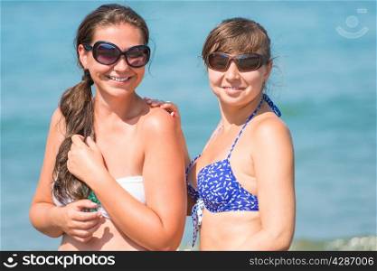 Portrait of of girlfriends with a beautiful smile on the beach