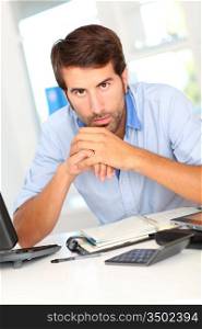 Portrait of office worker sitting at his desk