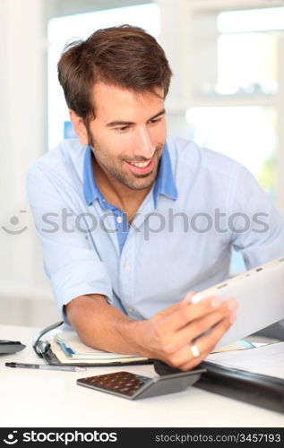 Portrait of office worker using electronic tablet