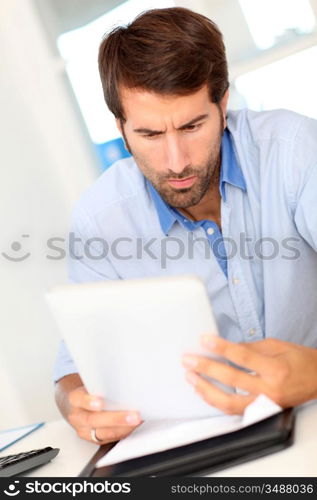 Portrait of office worker using electronic tablet