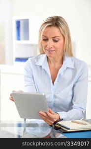 Portrait of office worker using electronic tablet in office