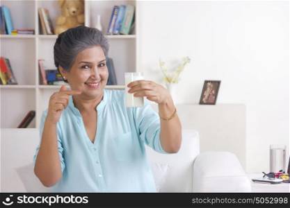 Portrait of old woman gesturing to glass of milk