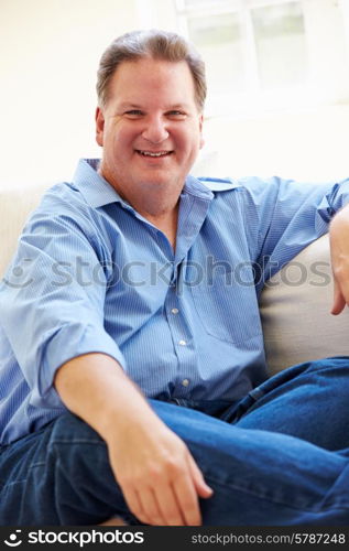 Portrait Of Overweight Man Sitting On Sofa