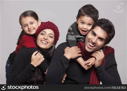 Portrait of parents and children over grey background
