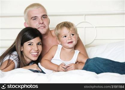 Portrait of parents and their son on a bed
