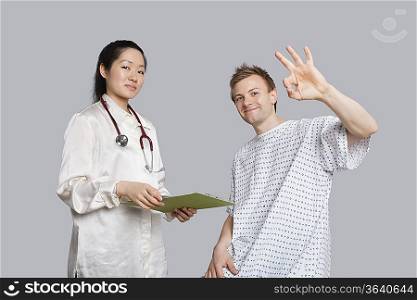 Portrait of patient gesturing okay with doctor holding a clipboard