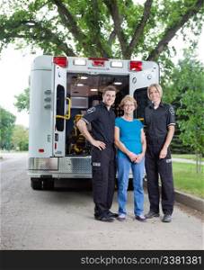 Portrait of patient with ambulance staff outside vehicle
