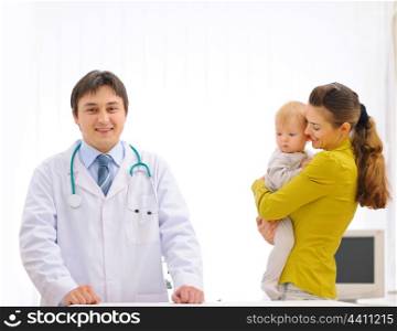Portrait of pediatric doctor and mother with baby on examination