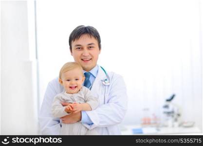 Portrait of pediatric doctor holding smiling lovely baby&#xA;
