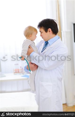 Portrait of pediatric doctor playing with baby &#xA;