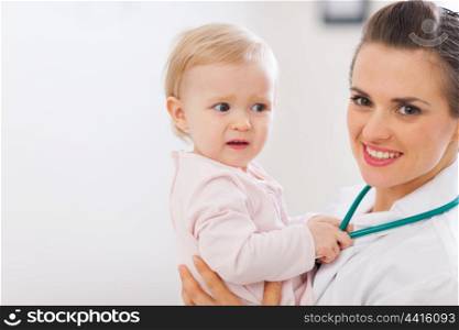 Portrait of pediatrician doctor with distrustful baby
