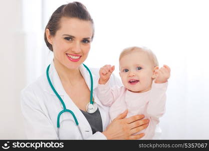 Portrait of pediatrician doctor with smiling baby