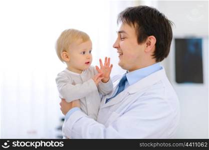 Portrait of pediatrician with baby on hands&#xA;
