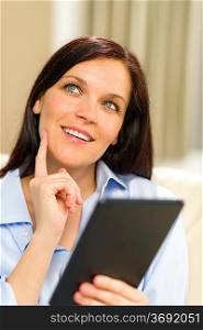 Portrait of pensive cheerful woman holding digital tablet