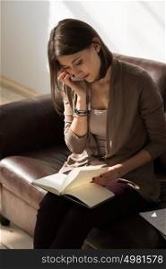 Portrait of pensive thinking business woman talking mobile phone and holding notepad or organizer and planning at her office