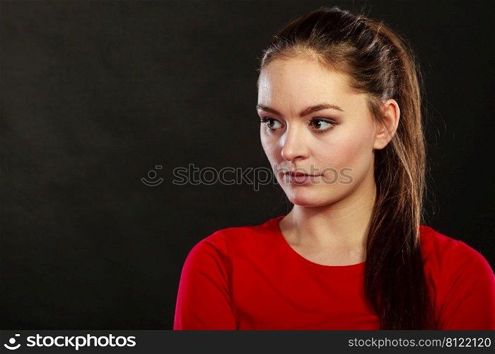 Portrait of pensive thoughtful woman. Attractive young girl thinking in studio on black.. Pensive thoughtful young woman girl.