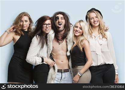 Portrait of playboy and happy women standing together against light blue background