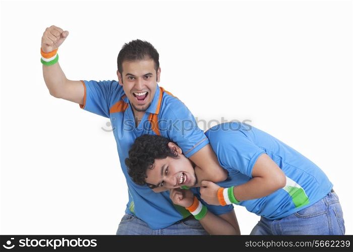 Portrait of playful young male friends in jerseys isolated over white background
