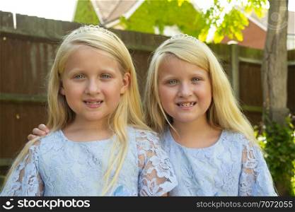 Portrait of pre teen twin caucasian girls looking at the camera themes of sisters siblings twins affection