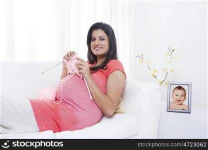 Portrait of pregnant mother knitting