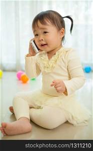 Portrait of pretty asian little girl talking on mobile phone