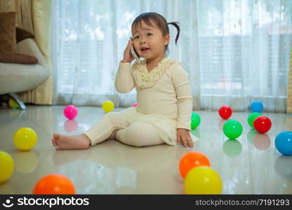 Portrait of pretty asian little girl talking on mobile phone