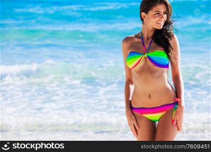 Portrait of pretty beautiful fashion woman in bikini posing in summer near the sea with gorgeous smile in happy mood on tropic island on vacation. Pretty woman in bikini near sea