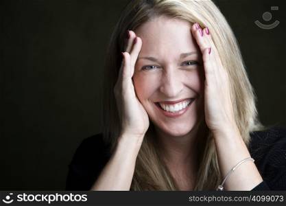 Portrait of pretty blonde laughing woman on a dark background