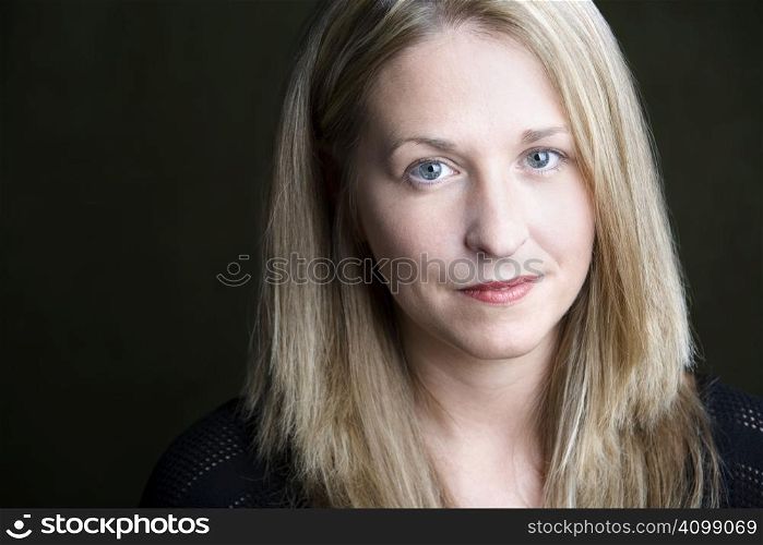 Portrait of pretty blonde woman on a dark background