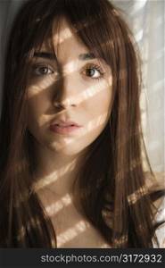 Portrait of pretty Caucasian young woman with sunlight through window.