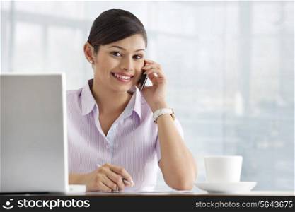 Portrait of pretty female executive using cell phone